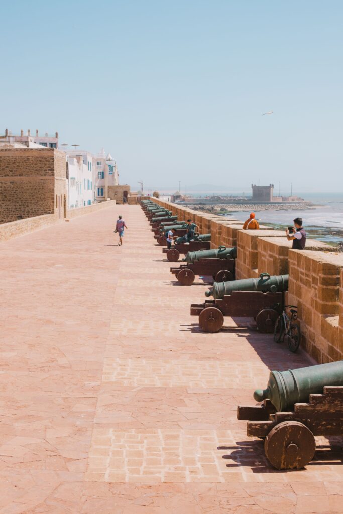 Row of historic cannons on the fortress wall in Essaouira, Morocco overlooking the Atlantic Ocean.