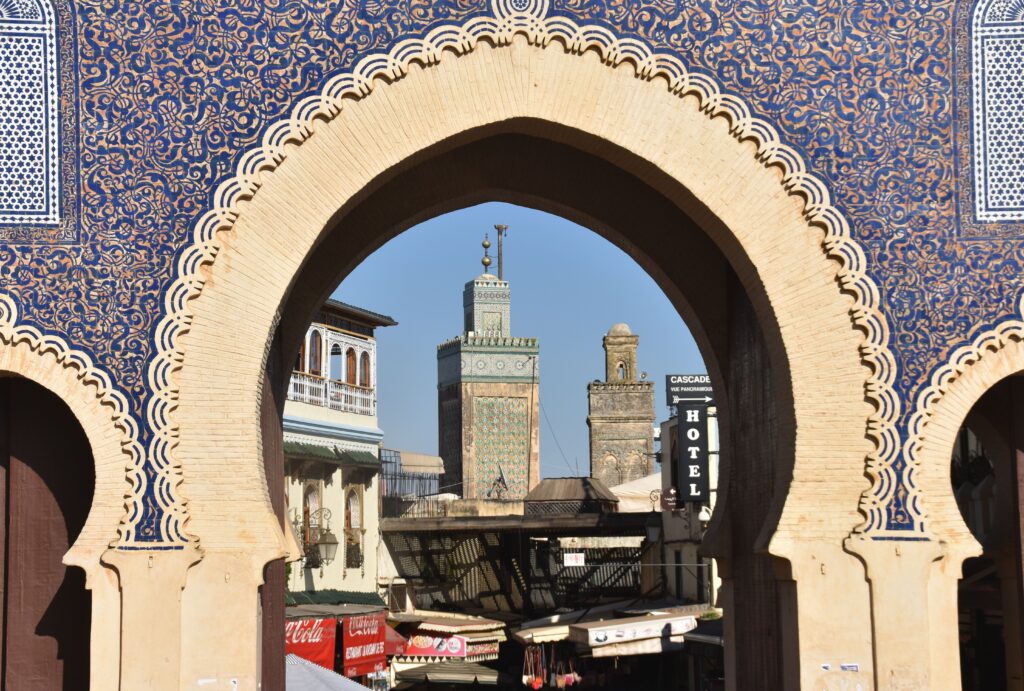A view through Bab Bou Jeloud archway in Fès, revealing the city's historic architecture and skyline.