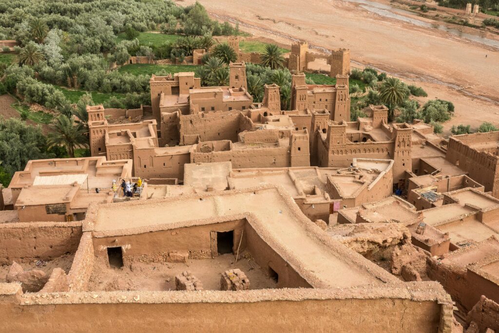 Discover the historic Aït Benhaddou, Morocco's iconic kasbah overlooking lush palm groves.