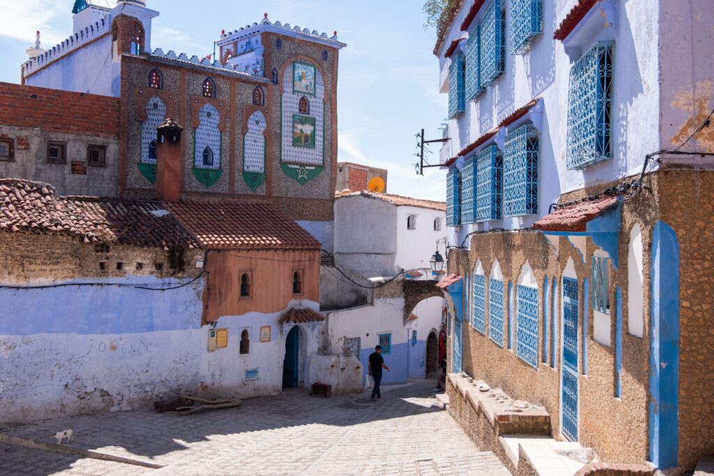 Colorful buildings and cobblestone streets in Chefchaouen, Morocco, a picturesque travel destination.